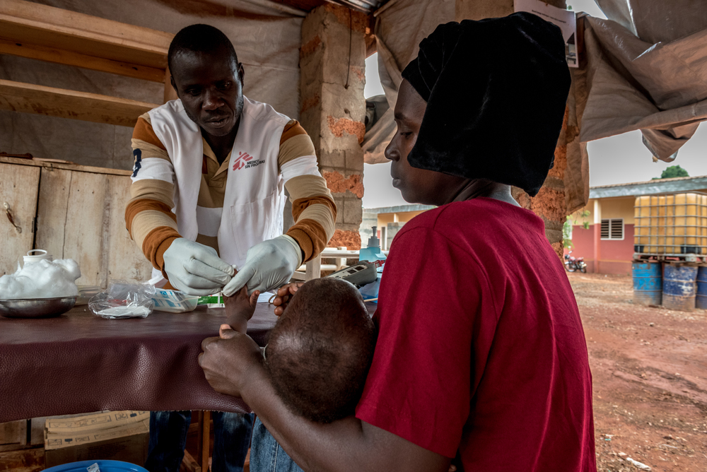 An MSF health worker tends to a young patient at an MSF project in Bangassou. 