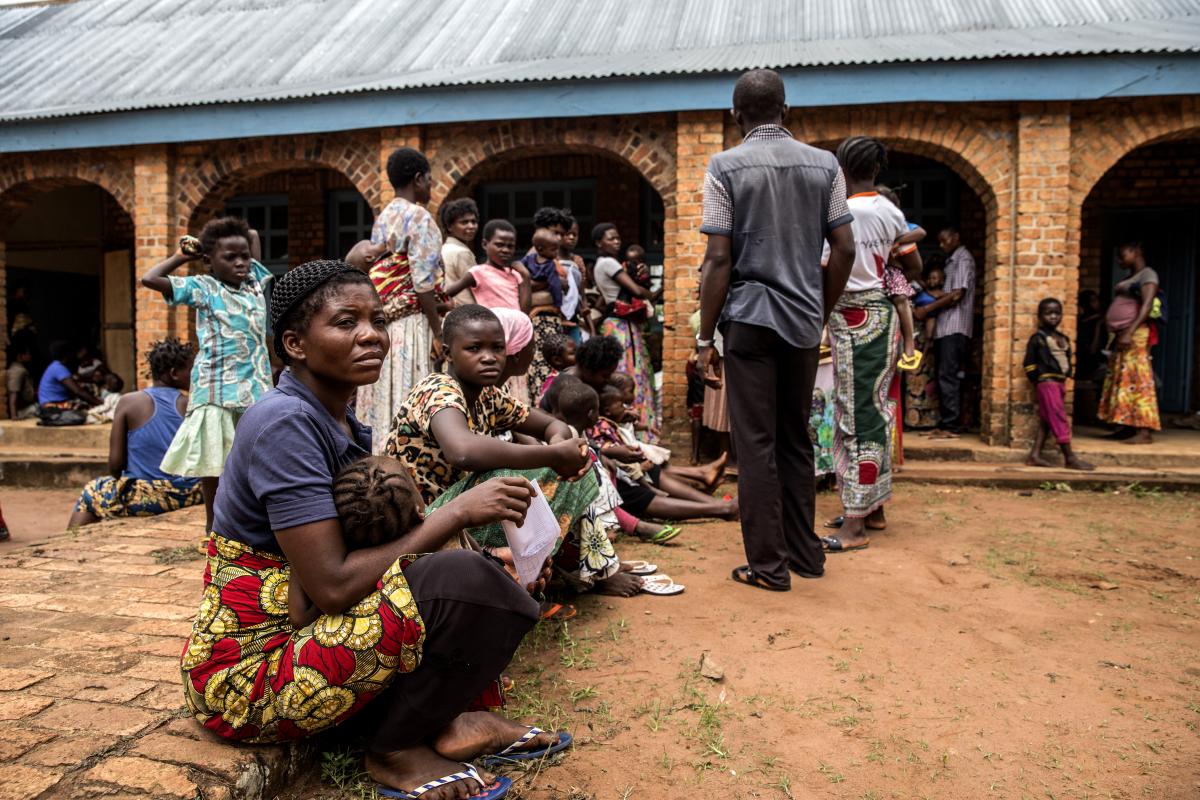 Mothers and children wait to be treated for malnutrition outside the Mayi Munene health center in DRC’s Kasai region. 