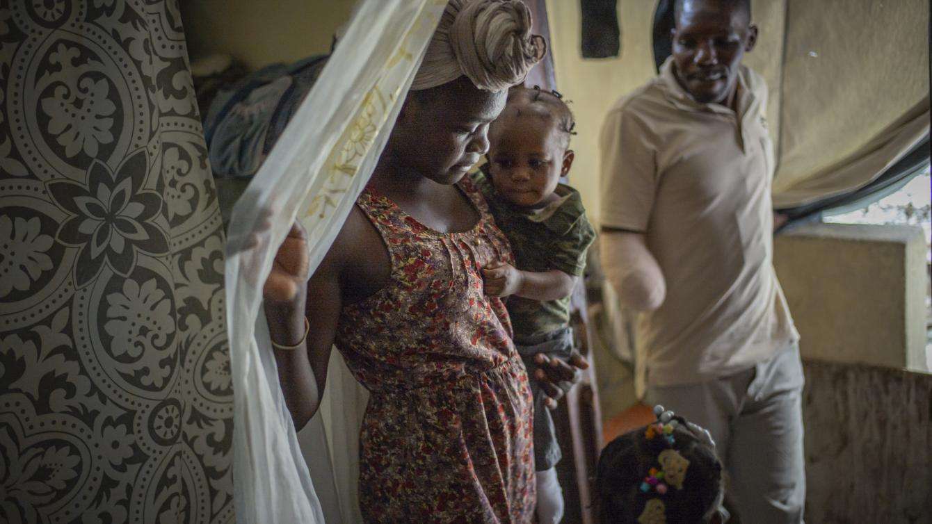 A man who is missing an arm stands with his family.