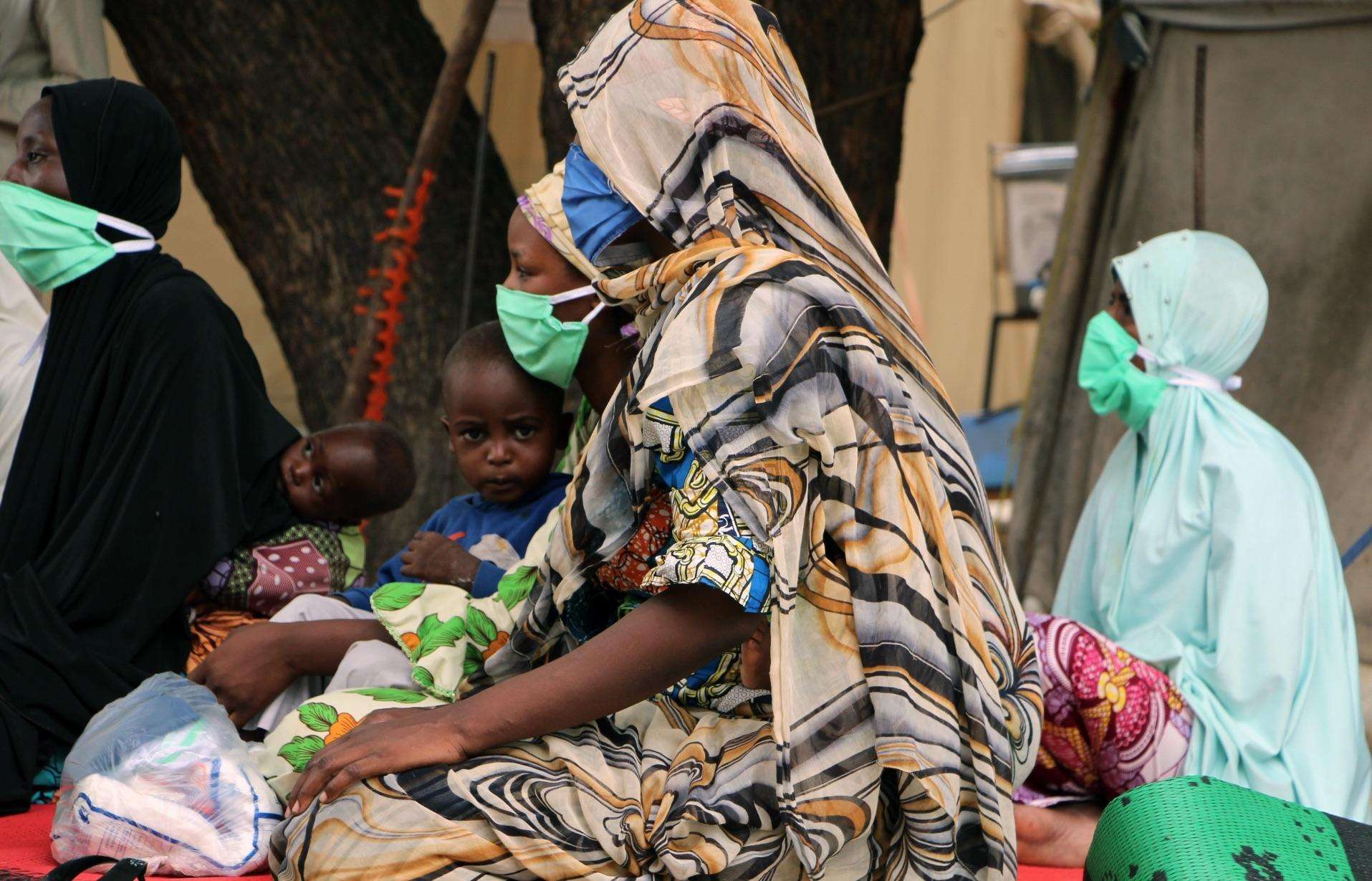 A mother and her children wear masks outside