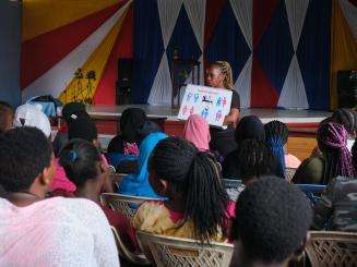 A peer talks to a group of teenagers about sex education at a church for outreach activities in Kenya.