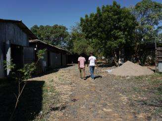 Two people walking down a dirt road