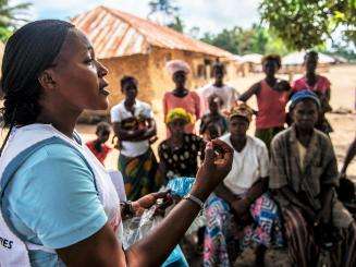 Health promoter, Emma Kamara, talks to villagers about health issues during a MSF outreach mission to treat survivors of Ebola. 