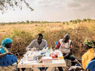 In the shade of a tree, mobile medical staff provide health consultations. Once per week, MSF sets up its medical clinic under trees in the village of Kier, on the banks of the Pibor River.