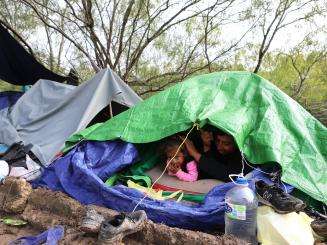 A family under plastic sheeting in Matamoros