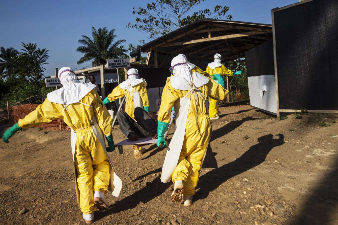 MSF staff transport a person who may have Ebola from an ambulance that broke down before reaching the MSF Ebola management center in Kailahun, a three-hour drive from the patient’s home. 