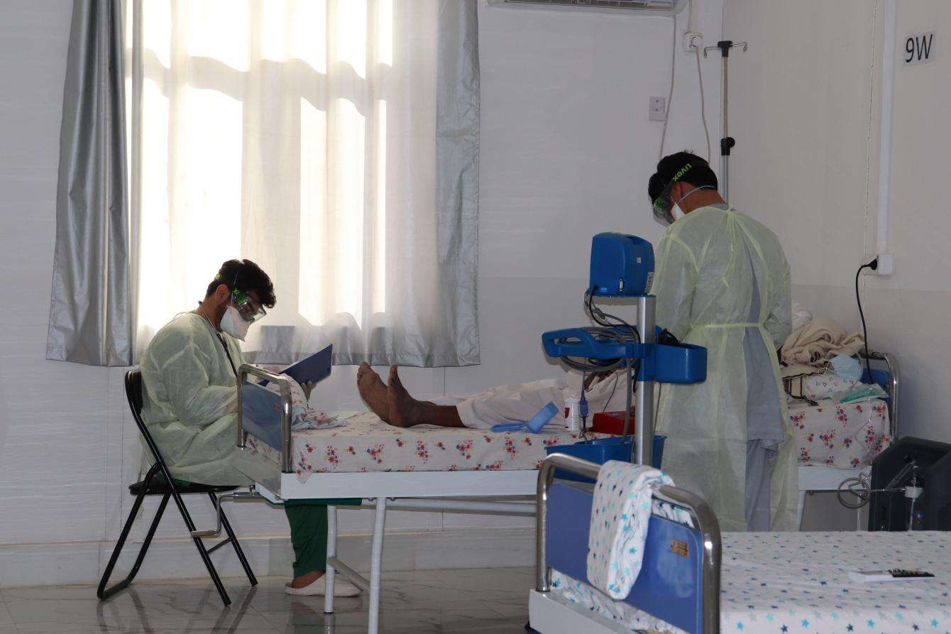 Medics tending to a patient around a hospital bed. 