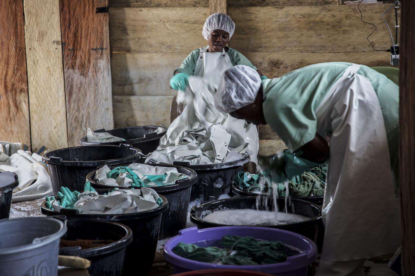 Hygienists disinfect personal protective equipment used by medical staff in an Ebola treatment center