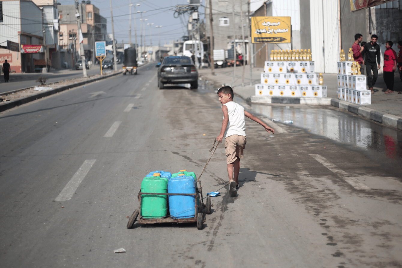 A Palestinian boy fetches water on a street in Gaza.