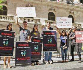 Protesters hold signs protesting Danaher prices as part of the Time for $5 campaign.