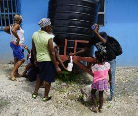 Displaced Haitians collect water.