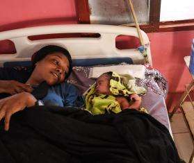 A woman with her baby in a hospital bed in South Darfur, Sudan.