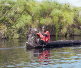 A man fishes aboard a canoe near Old Fangak, located alone one of the world's largest wetlands, the Sudd region.