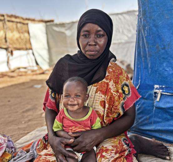 A Sudanese refugee woman holding her child in Chad.